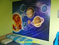 Stena v detskej izbe s fototapetou slnečnej sústavy má aj edukatívny charakter, čo ocení každý rodič.